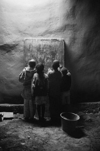 Underneath a street lamp, children study math in Sikasso, Mali late at night.