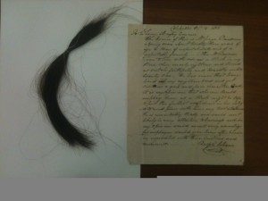 The lock of hair and letter of reference for George Ransom included in the back of Sherwood Ransom's whaling journal.