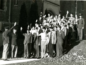 A group of students are inducted into the Army Air Corps Reserve by Captain Raymond Flint in front of Wood Hall, October 1942.