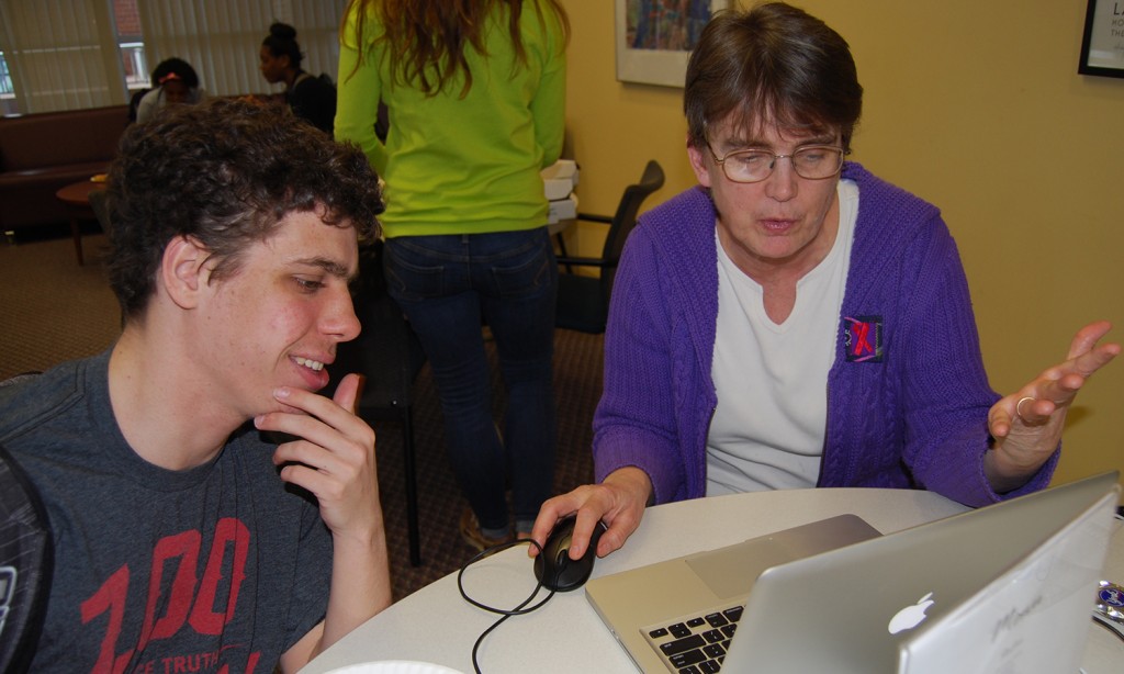 Subject Specialist Kathy Labadorf assists a student with his assignment.