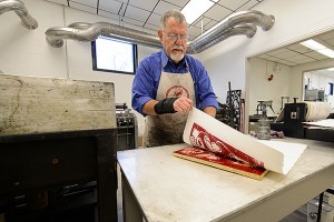 Gus Mazzocca, professor emeritus of art and art history makes a print at the new printmaking facility at the Bishop Center. 